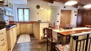 a kitchen with a table and a dining room at Appartamento LO SCOIATTOLO in Andalo