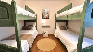 two bunk beds in a room with a cat sitting between them at Appartamento LO SCOIATTOLO in Andalo
