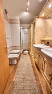 a large bathroom with two sinks and a toilet at Appartamento LO SCOIATTOLO in Andalo +11 photos