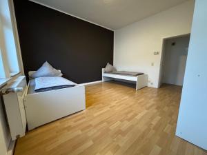 an empty room with two beds and a wall at Living - Ferien & Monteur Appartement in Wuppertal +2 photos