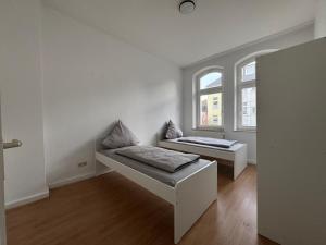 a room with two beds and two windows at Living - Ferien & Monteur Appartement in Wuppertal