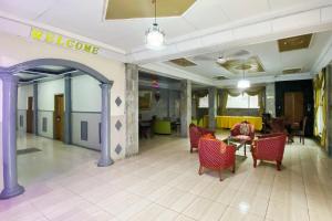 a lobby with red chairs and a welcome sign at RedDoorz Syariah At Hotel Matahari 1 Jambi in Jambi