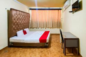 a bedroom with a bed and a desk in a room at RedDoorz Syariah At Hotel Matahari 1 Jambi in Jambi