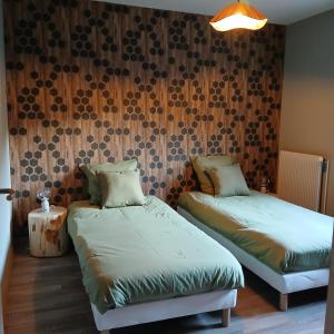 a bedroom with two twin beds and a wall with at La D'homette in Fresse-sur-Moselle