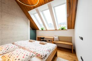 a bedroom with two beds and two windows at The Alpine House Otto in Begunje na Gorenjskem