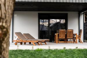 a pair of lounge chairs and a table on a patio at The Alpine House Otto in Begunje na Gorenjskem