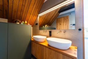 two sinks on a wooden counter in a bathroom at The Alpine House Otto in Begunje na Gorenjskem