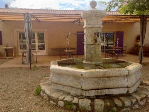 a stone fountain in front of a house at Domaine de la Ferme Para Lou in Sainte-Croix-de-Verdon +20 photos