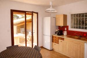 a kitchen with a white refrigerator and a table in it at La villa Cigaliere in Tulette