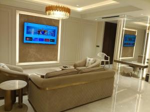 a living room with a couch and a tv at Dhiraj Dham in Nāthdwāra +13 photos