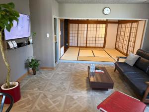 a living room with a couch and a table at 6名泊まれて鼓動を感じるシティウォークの拠点に-voyage- in Kumamoto