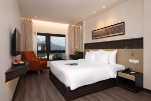 a bedroom with a large white bed and a chair at Hotel Montmartre de Sapa - Newly Opened April 2026 in Sapa +59 photos