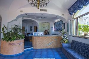 a lobby of a restaurant with a bar and a woman at Hotel Terme Saint Raphael in Barano d'Ischia +40 photos