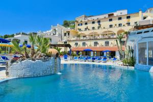 a swimming pool at a resort with a hotel in the background at Hotel Terme Saint Raphael in Barano d'Ischia