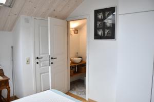 a bedroom with a white door and a sink at Au four et au jardin in Namur
