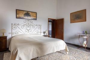 a bedroom with a white bed with a metal headboard at Podere le Lune with Pool, San Gimignano in San Gimignano
