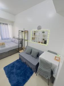 a room with two beds and a couch and a table at Ellain's Cozy Staycation-SMDC Green 2 Residences in Dasmariñas +5 photos