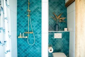 ein Badezimmer mit einer blau gefliesten Wand in der Unterkunft Notre Chalet - Boutique Appartements 4 étoiles & Sauna in Les Fourgs