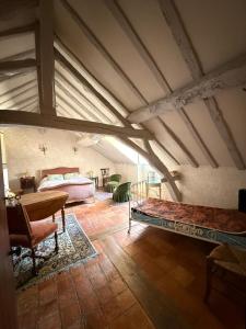 an attic room with two beds and a table at Lorcival in Savennières