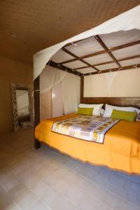 a bedroom with a large bed with a canopy at Fare Teiti Beach Bungalow in Haapiti