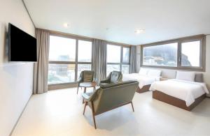 a hotel room with two beds and a flat screen tv at Sunrise Hotel Seongsan in Seogwipo +35 photos
