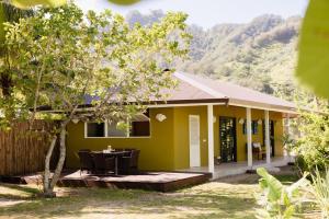 a yellow house with a table in front of it at Fare Teiti Beach Bungalow in Haapiti