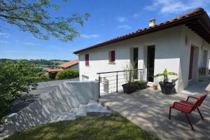 a red chair sitting on a patio in front of a house at La Parenthèse d'Hasparren - Avec Parking Privé in Hasparren