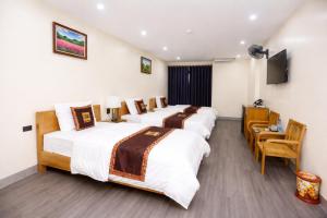 a hotel room with three beds and a flat screen tv at Hoa Cương Hotel 2- Hà Giang in Ha Giang +18 photos