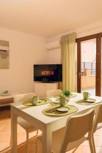 a dining room with a white table and chairs at SHARED SWIMMING POOL, House relax Lu Bagnu in Castelsardo