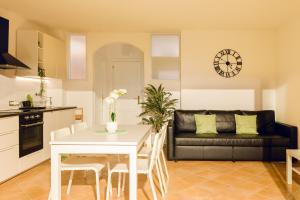 a kitchen and living room with a table and a couch at SHARED SWIMMING POOL, House relax Lu Bagnu in Castelsardo