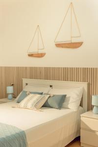 a bedroom with a white bed with three sails on the wall at SHARED SWIMMING POOL, House relax Lu Bagnu in Castelsardo