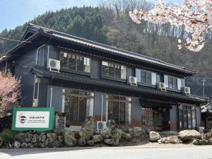 a building with a sign in front of it at SAKADONEguesthouse in Iijima