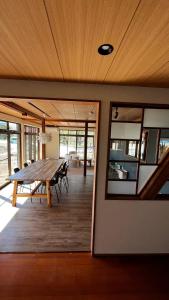 a dining room with a wooden table and chairs at SAKADONEguesthouse in Iijima