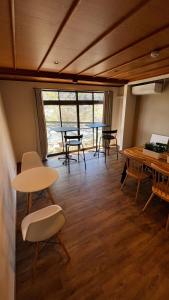 a room with tables and chairs and a large window at SAKADONEguesthouse in Iijima