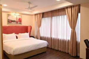 a bedroom with a bed and a large window at HOTEL NILACHAL - 10 Mins Travel to Kamakhya Temple, Guwahati in Guwahati +7 photos