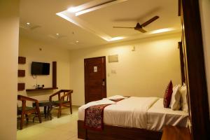 a bedroom with a bed with a ceiling fan at Tree Inn Jubilee in Hyderabad
