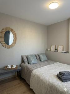 a bedroom with a bed and a table with a mirror at Naomi apartaments in Saldus