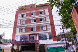 a tall red and white building on a street at Tree Inn Jubilee in Hyderabad