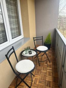 two chairs and a table on a balcony at Naomi apartaments in Saldus