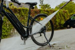 a person spraying a bike with a water hose at LPM Sporthotel Durbuy in Durbuy