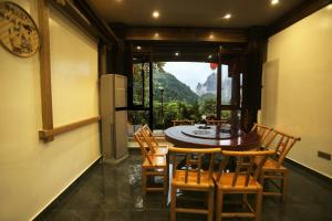 a dining room with a table and chairs and a window at Mountain-scenery inn in Zhangjiajie