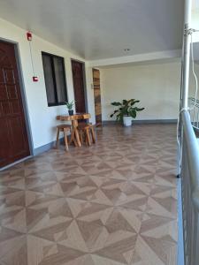 a room with a wooden floor and a table at D Estelita Guest House in Moalboal