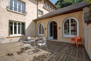 a patio with chairs and a table on a deck at Le Clos des Soyeux in Saint-Victor-sur-Rhins