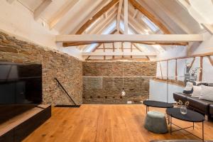 a living room with a couch and a brick wall at Glamorous Cottage mit Kamin und Sauna in Dahlem