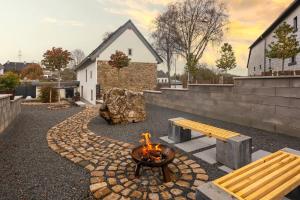 a fire pit with a bench and a fire pit at Glamorous Cottage mit Kamin und Sauna in Dahlem