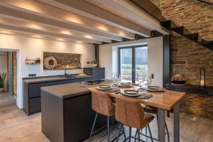 a kitchen with a table with chairs and a counter at Glamorous Cottage mit Kamin und Sauna in Dahlem