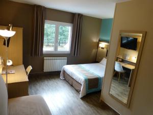 Säng eller sängar i ett rum på Hotel ARBOR - Les Hunaudieres - Le Mans Sud - Mulsanne