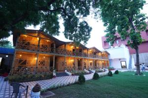 a large building with a balcony in a yard at Hotel First Impression in Rāmnagar