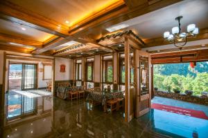 a dining room with a table and chairs and a large window at Mountain-scenery inn in Zhangjiajie