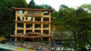 a yellow building with a chinese roof at Mountain-scenery inn in Zhangjiajie